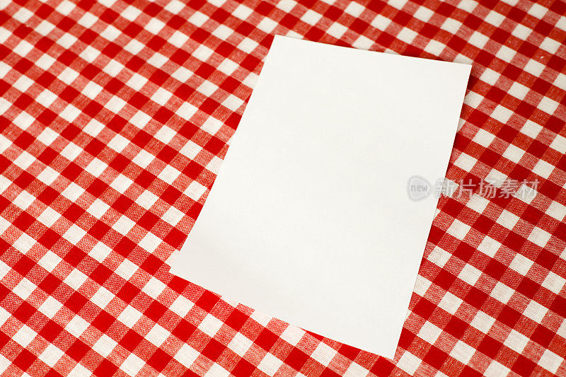 红方格布桌布上的纸。