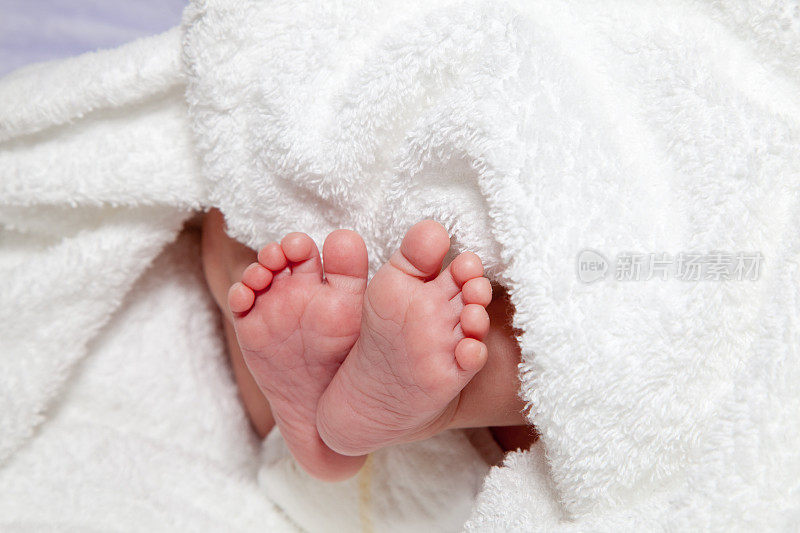 婴儿脚底包裹在白色的柔软毛巾布
