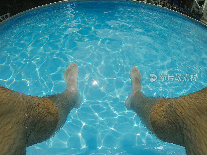 脚在游泳池里