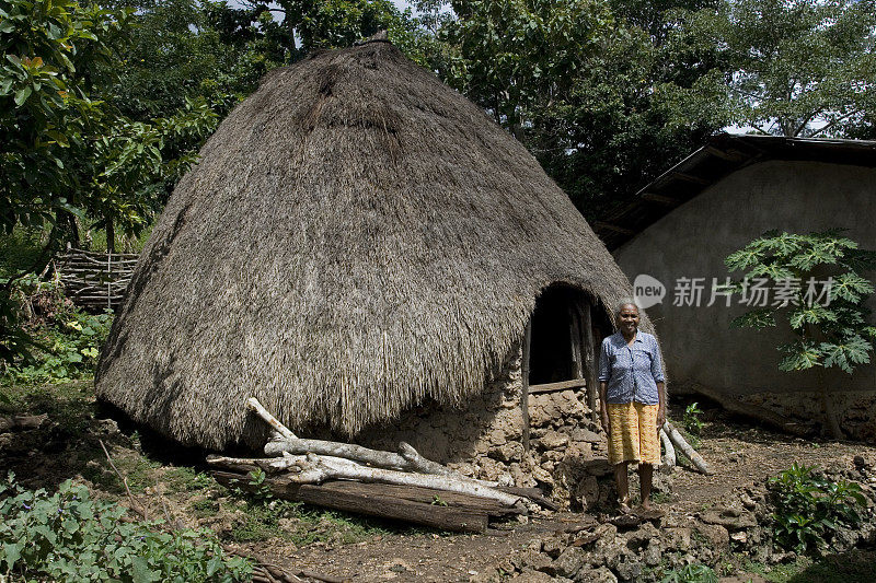 老村民在传统的锥形房屋前。