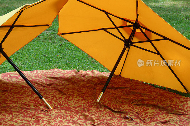 毯子上的黄色沙滩伞
