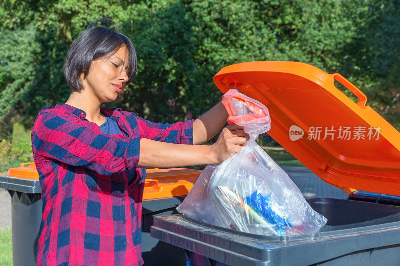 一位荷兰妇女把塑料垃圾扔进垃圾桶