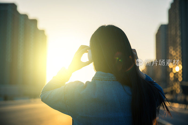 女性戴着耳机听音乐