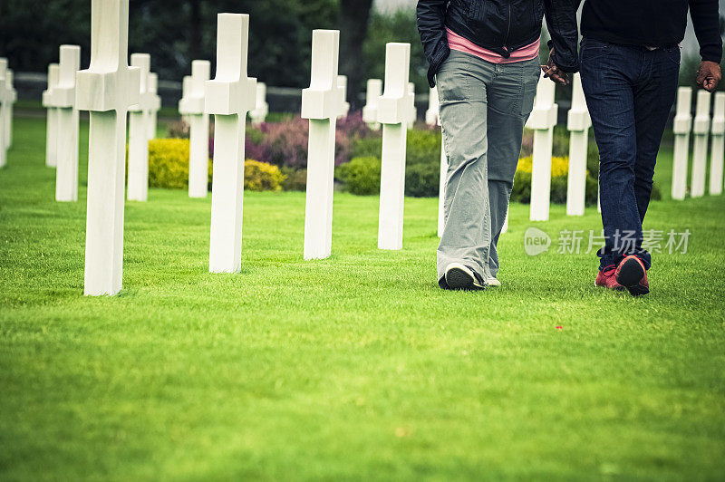 人们走在诺曼底的美军墓地里