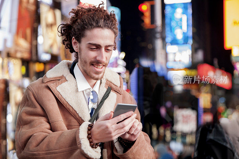 纽约时代广场，一个拿着手机的男人。