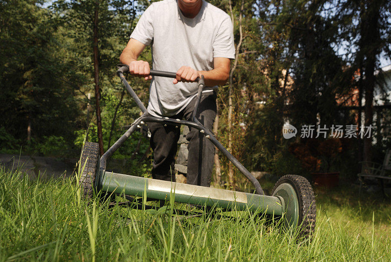 用推式割草机割草坪。
