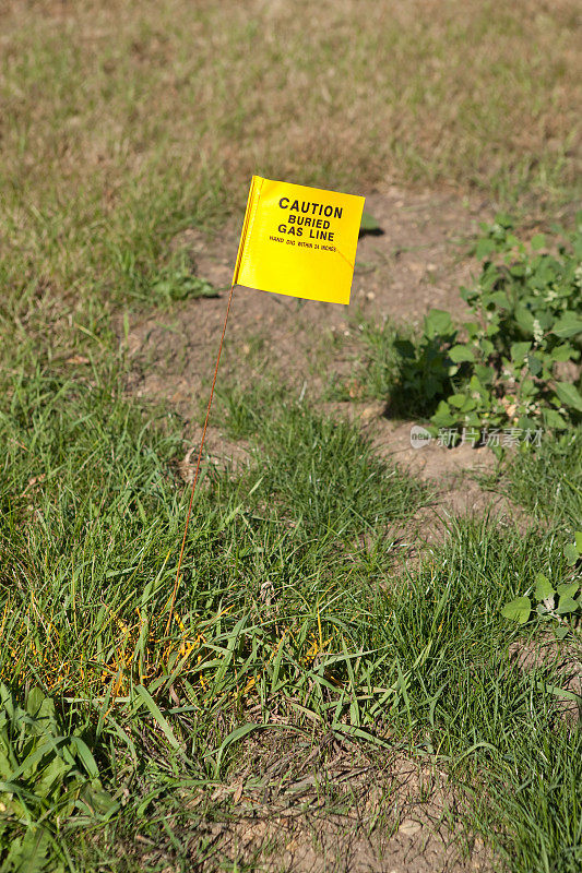小心埋在地下的煤气管道旗帜和草地上的黄色条纹
