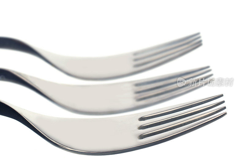 三把叉子放在白色的背景上