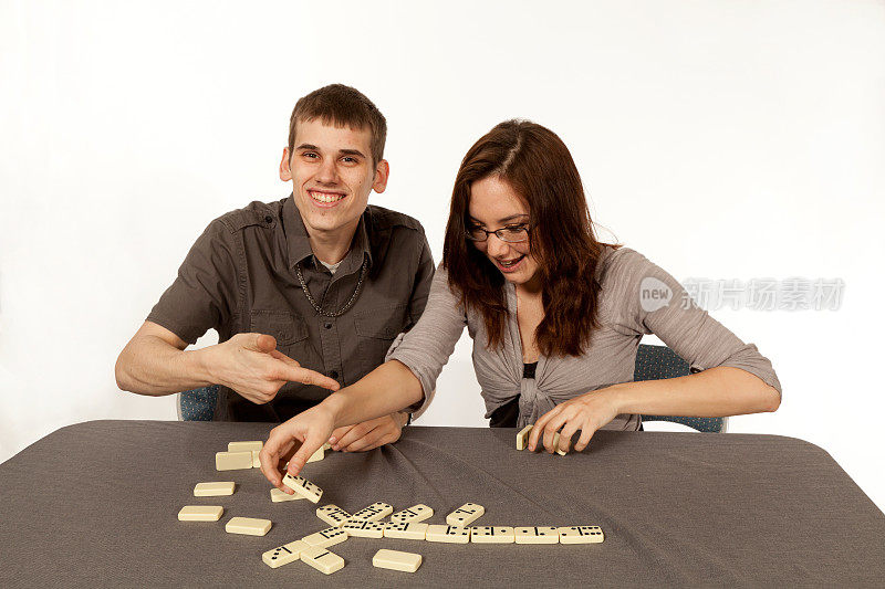 年轻夫妇在玩多米诺骨牌