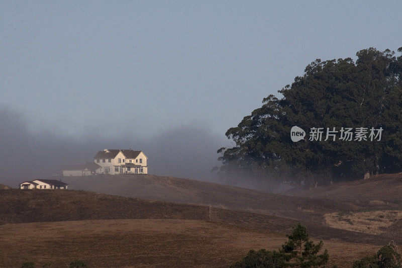 山上的农舍被晨雾包围着