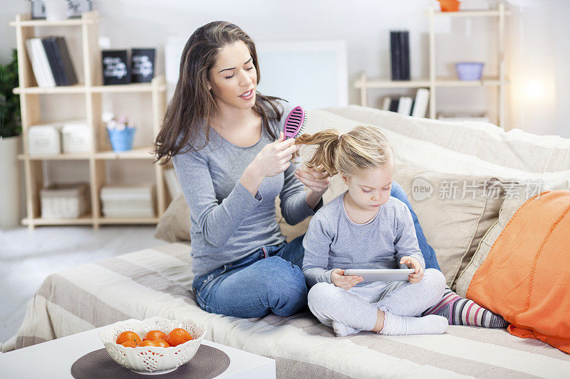 妈妈和女儿在客厅玩平板电脑