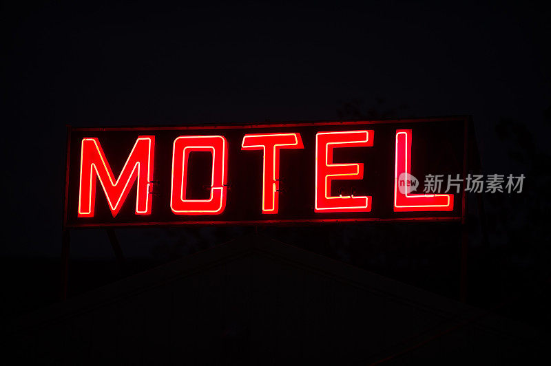 汽车旅馆的标志在红色霓虹灯的夜晚，黑色的背景