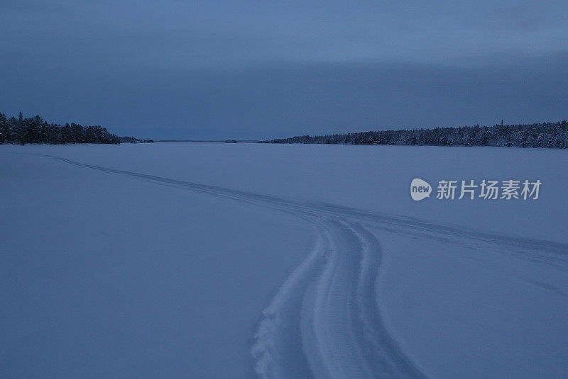 夜幕降临时雪地上的小路