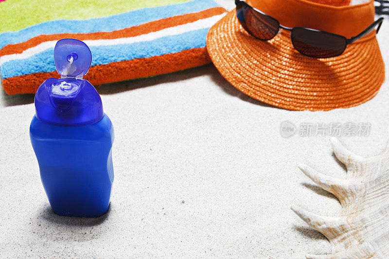 海滩上有毛巾，太阳镜，防晒霜，贝壳，帽子和拷贝空间