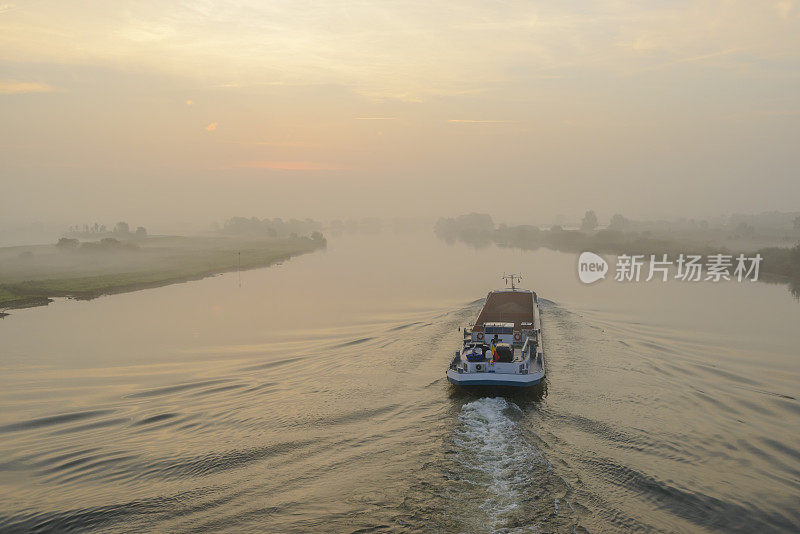 在一个美丽的秋天的早晨，船在IJssel河上的日出