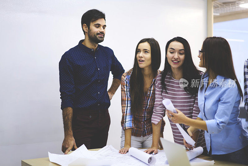 熟练的女学生与专业教练一起咨询，检查建筑项目的平面费用，提出建议和改进的规划理念，团队同事一起集思广益