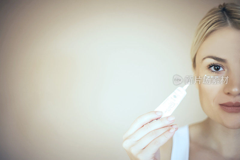 女人优雅的化妆应用血清治疗。副本的空间。