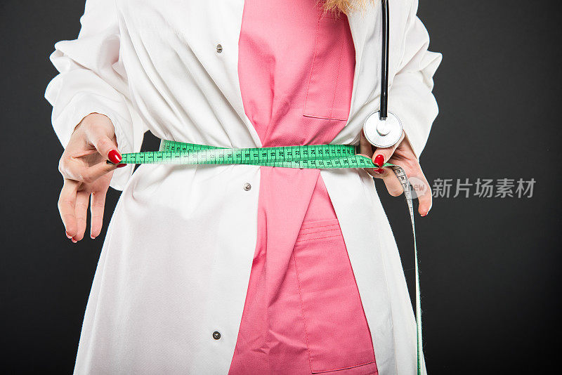 女医生用卷尺测量自己的特写