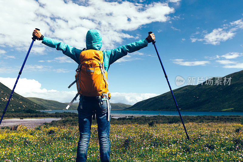 为在山里徒步旅行的年轻背包女欢呼