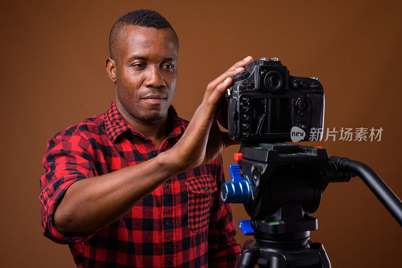 工作室拍摄的肌肉非洲男子准备在彩色背景下做视频博客