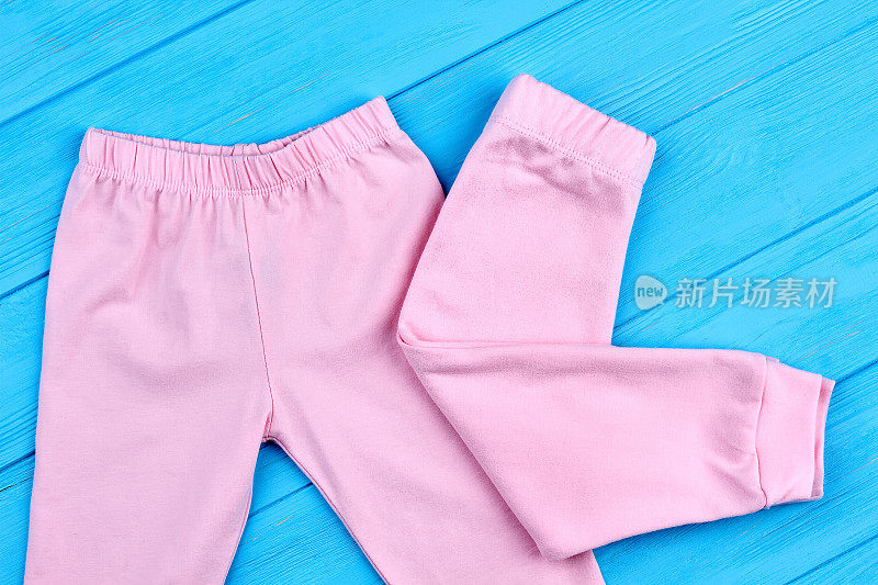 小女孩穿的时髦的粉红色裤子。