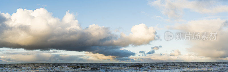 日落时波罗的海戏剧性的多云天空，船只在地平线上。