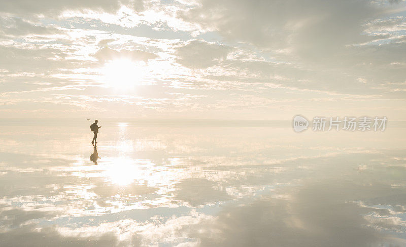 摄影师与无人机在盐湖上玩日落
