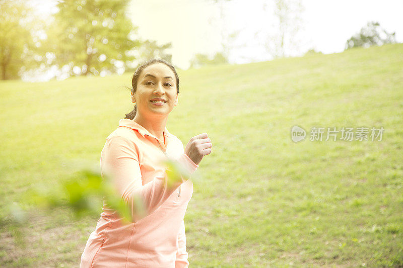 一位拉丁裔妇女在附近的公园里跑步。