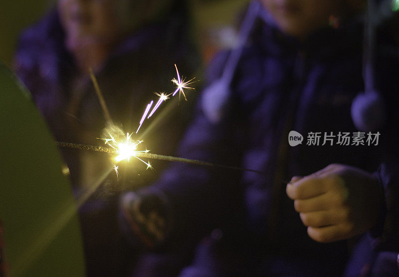 孩子们拿着熊熊燃烧的烟火庆祝新年