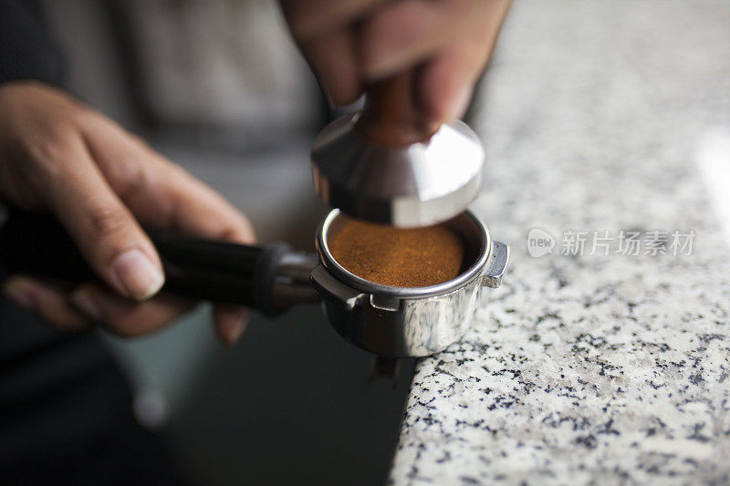 咖啡师用捣锤制作浓缩咖啡