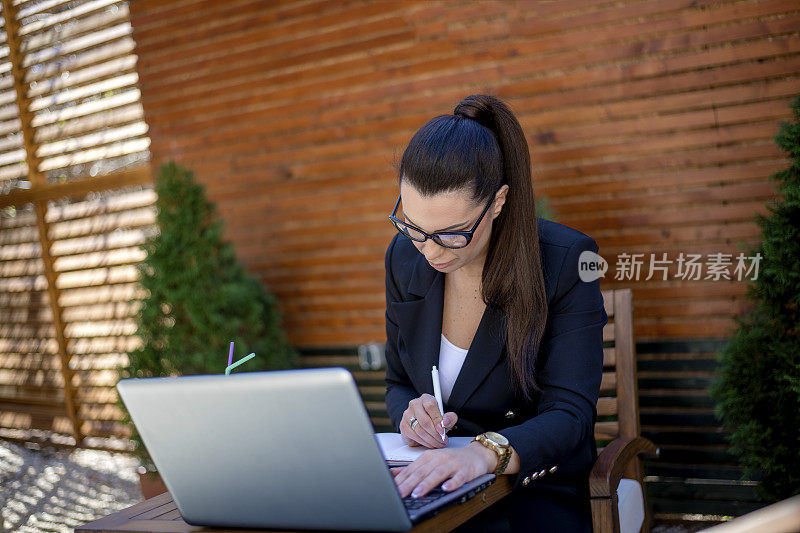 年轻的女商人在café用笔记本电脑工作