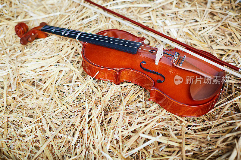 小提琴和弓躺在谷仓的稻草里