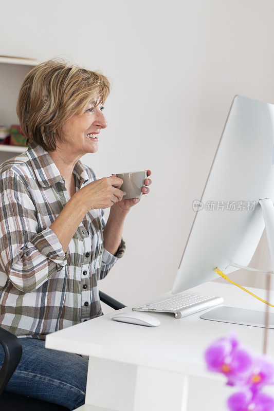 年长妇女在家里使用电脑