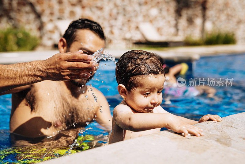 拉丁父子在夏天的游泳池里。