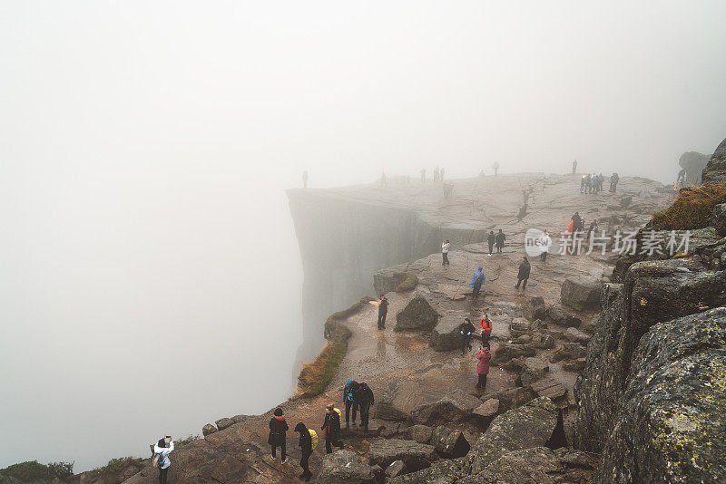 一群游客在迷雾中漫步在布道石上