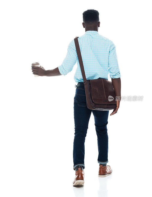 z一代年轻男性走在白色背景前，戴着信使包，拿着包