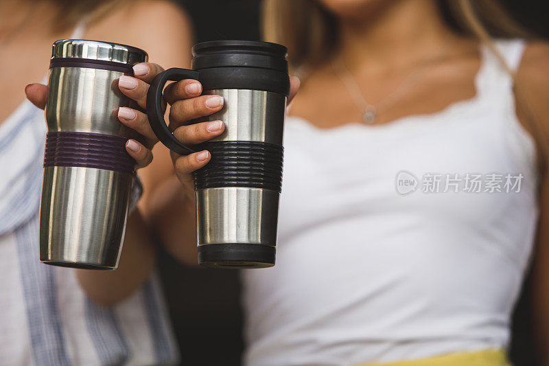 从两个拿着咖啡保温瓶的年轻女人身上剪下来的