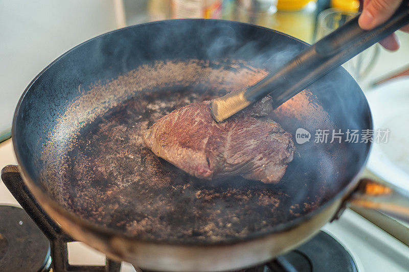 臀部牛排在金属锅里烤，特写