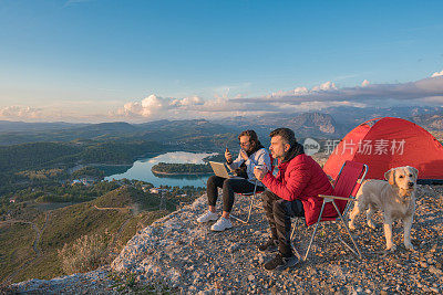 两个好朋友和他们的狗在山顶露营。