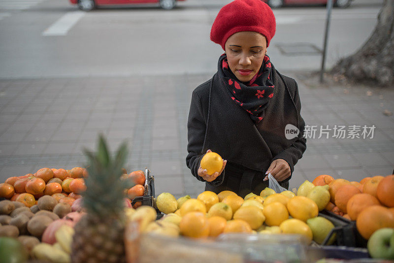 肤色不同的妇女在传统市场挑选水果