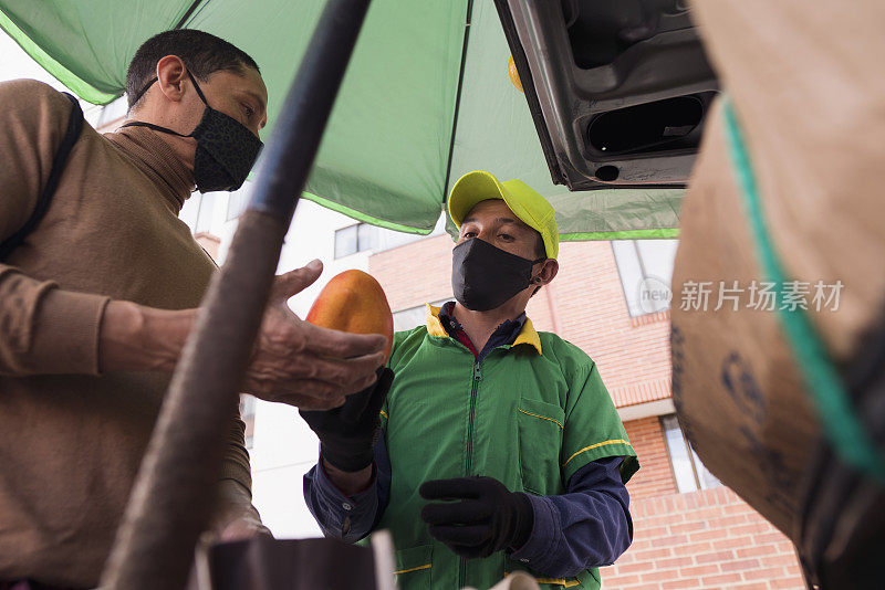 卖主和顾客观察水果