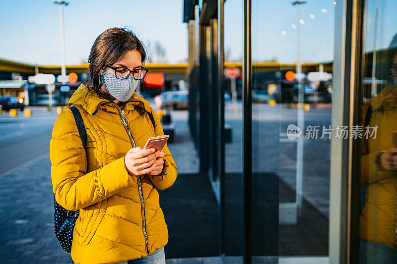 一个女人在购物中心戴着口罩打电话