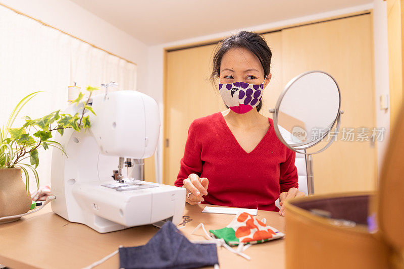 一名日本妇女在家里制作面具