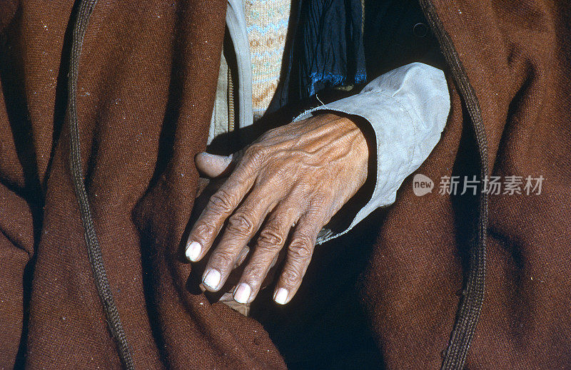 在阿尔及利亚的撒哈拉难民营，一个穿着阿拉伯风格的成年人的手