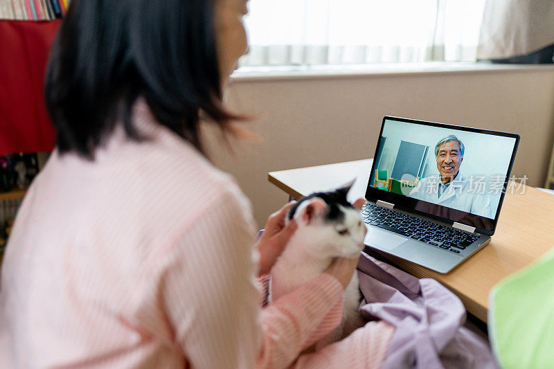 远程健康-妇女视频聊天与医生在家里的笔记本电脑