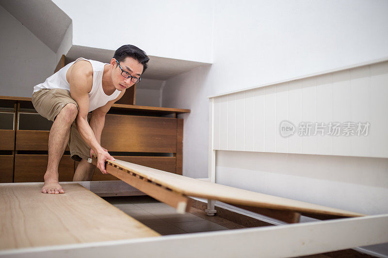 一个成熟的亚洲男人正在安装家具。