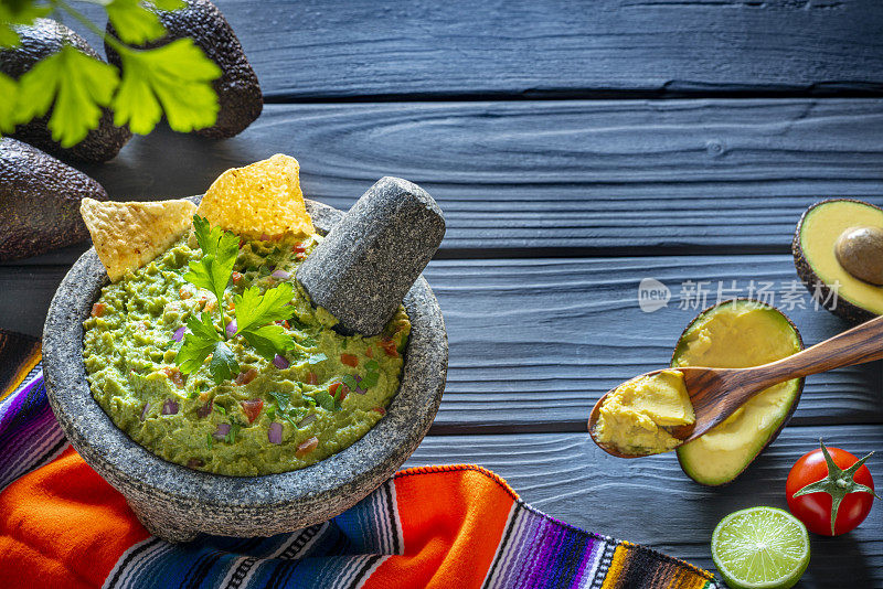 牛油果墨西哥食谱，在石头molcajete与原料在黑木