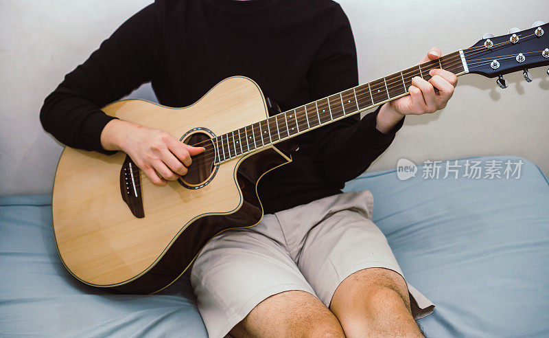 男人在床上弹吉他