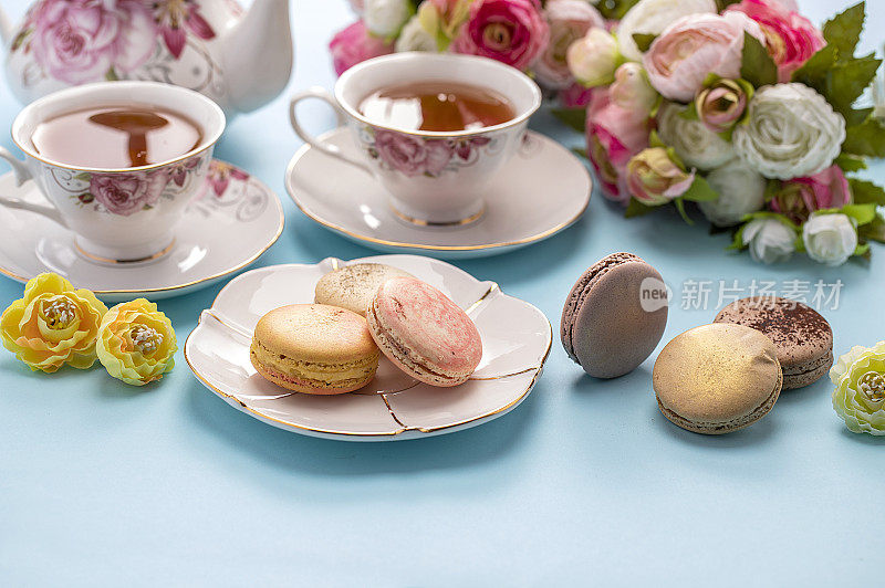 红茶和许多色彩鲜艳的马卡龙摆放在桌上