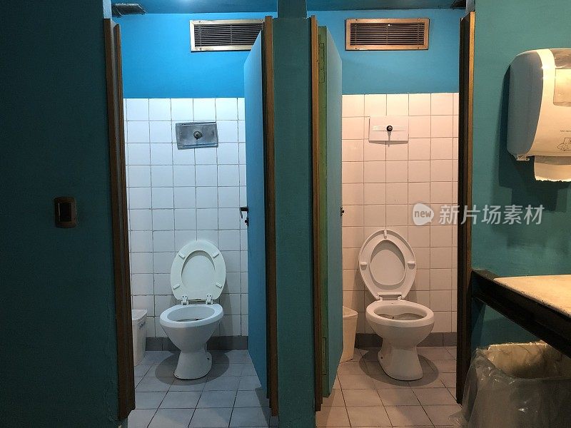 一个旧的公共厕所，蓝色的墙壁和白色的瓷砖